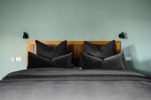 a bedroom with a large bed with black pillows at The View Bright - Apartment 1 in Bright