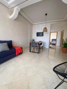 - un salon avec un canapé bleu et une table dans l'établissement Appartement Dahomey Bouznika, à Bouznika