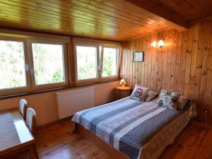 a bedroom with a bed with wooden walls and windows at Spacious holiday home in Kopalino in Kopalino