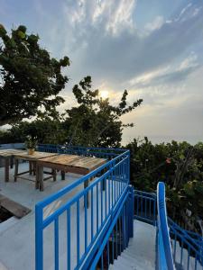 una cerca azul y una mesa de picnic en una cubierta en Má Năm Homestay en Phương Phi