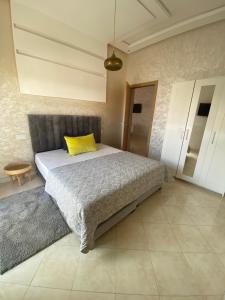 - une chambre avec un lit doté d'un oreiller jaune dans l'établissement Appartement Dahomey Bouznika, à Bouznika