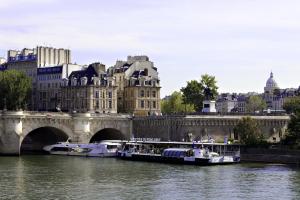 two boats on the river in front of a bridge at Hotel Ducs de Bourgogne in Paris