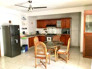 La cuisine est équipée d'une table, de chaises et d'un réfrigérateur. dans l'établissement Casa Bocoyna, à Acapulco