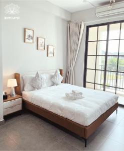 a bedroom with a bed and a large window at White Lotus Hotel - Swanbay in Phước Lý
