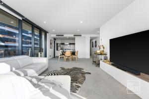 een woonkamer met een tv en een zebratapijt bij Spectacular Victoria Harbour Apartment Docklands in Melbourne