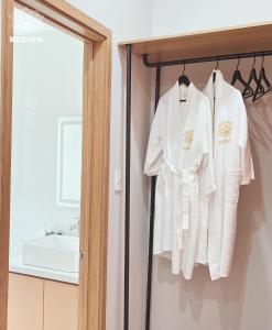 a bathroom with white robes hanging on a rack at White Lotus Hotel - Swanbay in Phước Lý