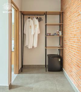 a closet with white shirts hanging on a brick wall at White Lotus Hotel - Swanbay in Phước Lý
