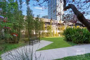 een park met een bank in het midden van een tuin bij Spectacular Victoria Harbour Apartment Docklands in Melbourne