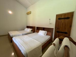 Habitación de hotel con 2 camas y sofá en Rivendell Twisted Tree, en Kurunegala