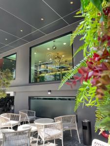 City Park Hotel Bangkok Pratunam by PCL في بانكوك: مطعم بطاولات وكراسي ونافذة كبيرة