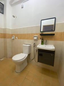 a bathroom with a toilet and a sink and a mirror at Comfy Sutera Seberang Jaya in Kampong Belah Dua