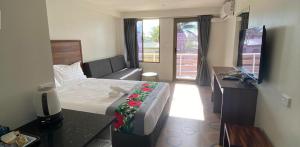 a hotel room with a bed and a television at Vualiku Hotel & Apartments in Nadi