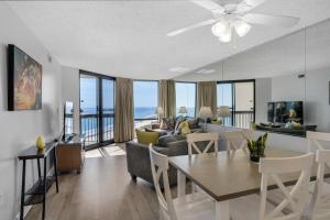 a dining room and living room with a couch and a table at SunDestin 1415 in Destin