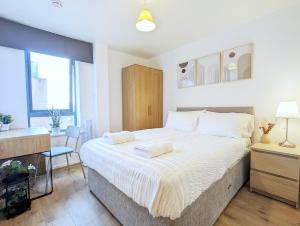 a bedroom with a large bed and a desk at 2-bedroom Apt Near Key Attractions Free Parking in Liverpool