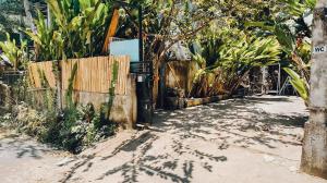 eine unbefestigte Straße mit einem Zaun und einigen Pflanzen in der Unterkunft Panayota House in Kuta Lombok