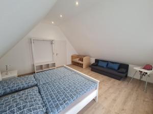 1 dormitorio con 1 cama azul y 1 sofá en Ferienhaus Gräbner, en Lügde