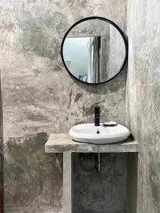 een badkamer met een wastafel en een spiegel bij Panayota House in Kuta Lombok