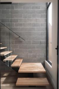 a staircase in a room with a brick wall at Stadium View Townhouse in Geelong