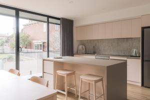 a kitchen with a large island with stools at Stadium View Townhouse in Geelong