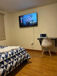 a bedroom with a tv hanging on the wall at Departamento de 2 Habitaciones, full amoblada con todo para que disfrutes de tu Estancia in Cuenca