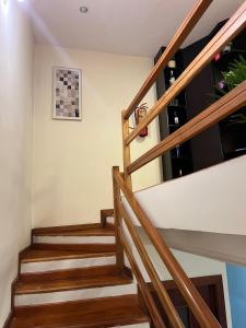 a staircase in a house with wooden railings at Departamento de 2 Habitaciones, full amoblada con todo para que disfrutes de tu Estancia in Cuenca