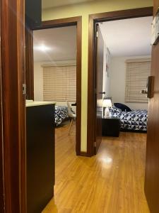 a room with a door open to a room with a bedroom at Departamento de 2 Habitaciones, full amoblada con todo para que disfrutes de tu Estancia in Cuenca