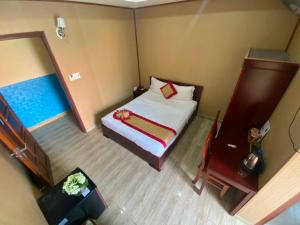 a small room with a bed and a mirror at Hoa Sua Hotel in Vung Tau