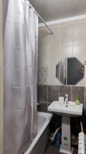 ein Badezimmer mit einem Waschbecken, einer Badewanne und einem Spiegel in der Unterkunft 2-х комнатная квартира in Qysylorda