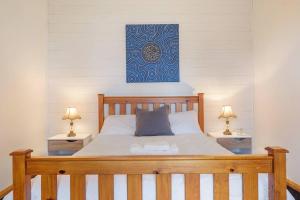 ein Schlafzimmer mit einem großen Holzbett mit zwei Lampen in der Unterkunft Peaceful Bruny Island Shack in Dennes Point