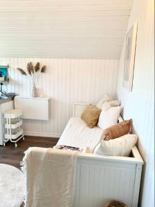 un letto in una camera con pareti bianche di SeaSide a Hjälteby