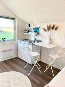 a kitchen with a desk and chairs in a room at SeaSide in Hjälteby