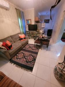 a living room with a couch and a table at #1 Jacaranda Vacation Home in Spanish Town