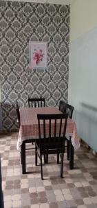 弄邊港的住宿－Homestay D'Hiburan Kuala Rompin，餐桌、两把椅子、一张桌子和一面墙