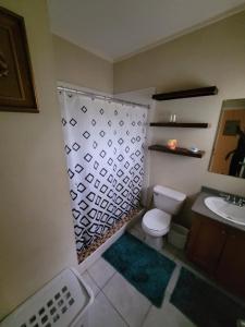 a bathroom with a toilet and a sink at #1 Jacaranda Vacation Home in Spanish Town