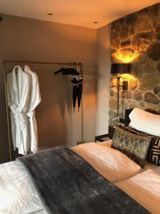 1 dormitorio con cama y pared de piedra en Chill-out, en Nieuwe Wetering