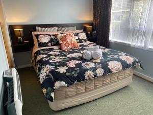 a bed with two mugs on it in a bedroom at The Cozy Hutt Home in Upper Hutt