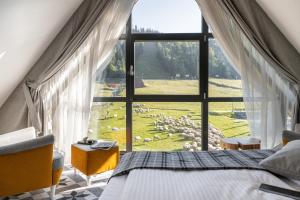 sypialnia z dużym oknem z owcami na polu w obiekcie Apartamenty Pod Stokiem Nosal Zakopane w Zakopanem