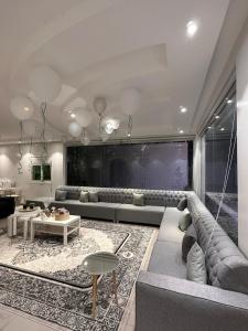 uma sala de estar com um sofá e uma mesa em شاليه وردة الدرة em Unayzah