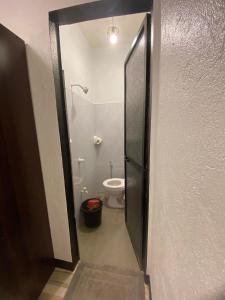 a bathroom with a toilet and a door to a bathroom stall at Shanti's Inn in General Luna
