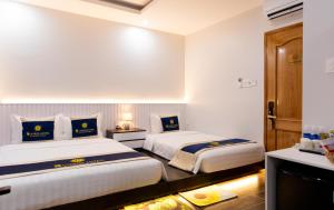 een hotelkamer met 2 bedden en een televisie bij SUNRISE Hotel Bạc Liêu in Bạc Liêu