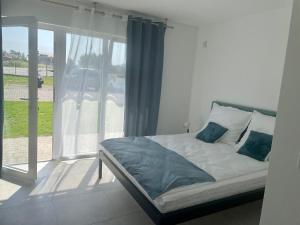 a bed sitting in a room with a window at Pensjonat VICTORIA in Ustka