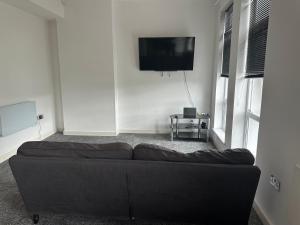 a living room with a couch and a flat screen tv at Homestay with free wi-fi, parking and more in Darlington