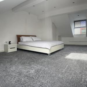 a white bedroom with a bed and a window at Homestay with free wi-fi, parking and more in Darlington