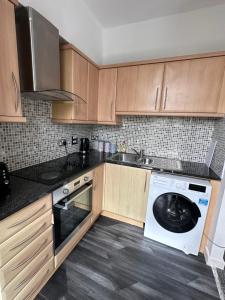 a kitchen with wooden cabinets and a washing machine at Homestay with free wi-fi, parking and more in Darlington
