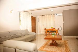 ein Wohnzimmer mit einem Sofa und einem Tisch in der Unterkunft Nest and Nomad Homestay in Daressalam
