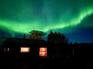 an aurora over a house and a house at Gljásteinn by Golden Circle in Laugarvatn