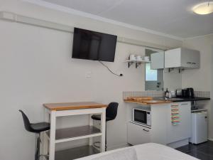 una pequeña cocina con mesa y encimera en Redcliffe Homestay, en Redcliffe