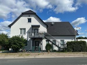 une grande maison blanche avec un toit noir dans l'établissement Design Apartment Sasaki, à Celle