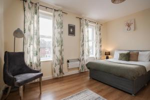 a bedroom with a bed and a chair and a window at Huge 5BDRM Ensuite in Liverpool Monthly discounts Bu Hinkley Homes Short Lets & Serviced Accomodation in Liverpool