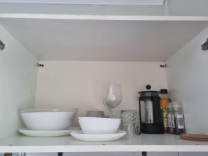 a shelf with two bowls and a wine glass at Redcliffe Homestay in Redcliffe